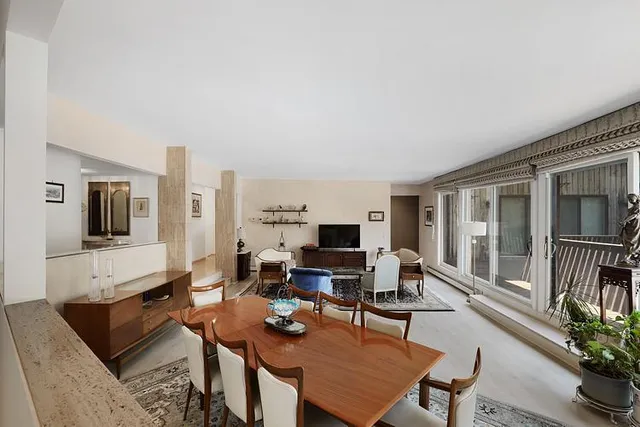 a living room with furniture a flat screen tv and a large window