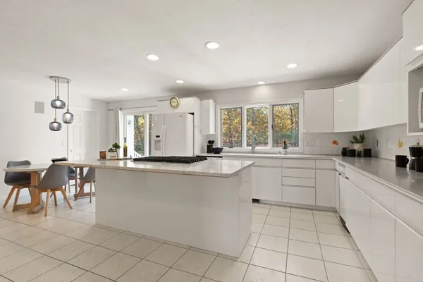 a kitchen with appliances cabinets and chair