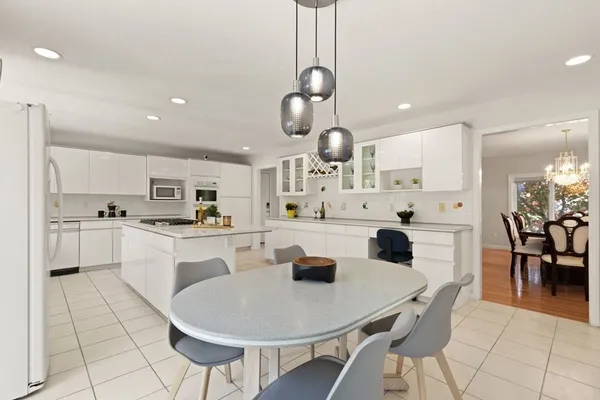 a kitchen with stainless steel appliances kitchen island granite countertop a sink a stove a counter top space and cabinets