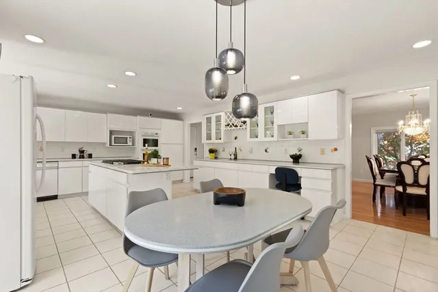 a kitchen with stainless steel appliances kitchen island granite countertop a sink a stove a counter top space and cabinets