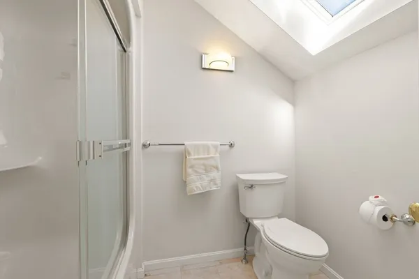 a white toilet sitting next to a shower
