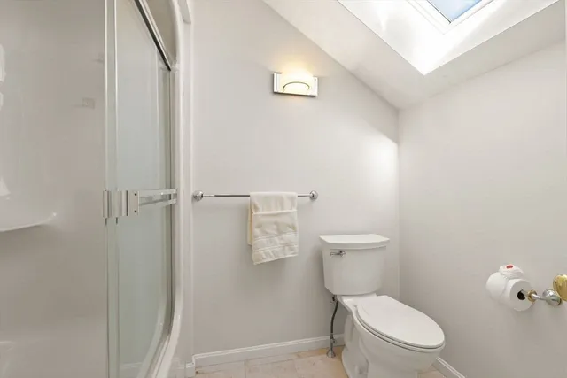 a white toilet sitting next to a shower