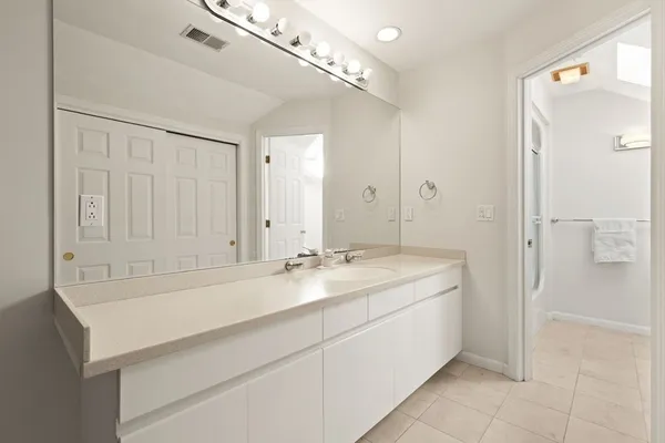 a spacious bathroom with a sink a mirror and a shower