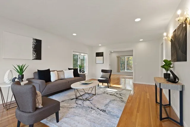 a living room with furniture a wooden floor and a flat screen tv