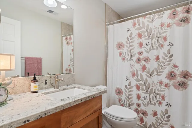 a bedroom with a bed and a dresser next to a window