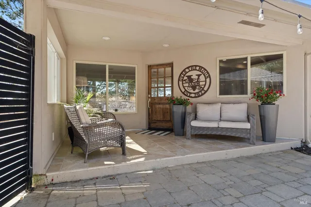 a living room with fireplace furniture and a large window