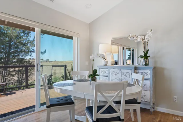 a kitchen with stainless steel appliances granite countertop a stove a sink dishwasher a refrigerator and white cabinets with wooden floor