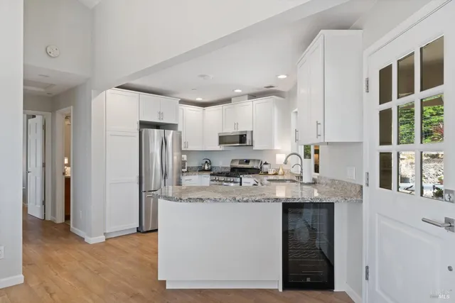 a kitchen with granite countertop a stove a sink and a microwave
