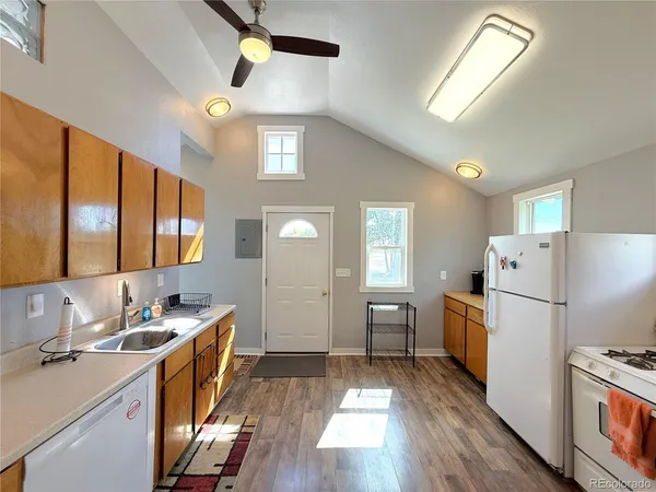 a kitchen with sink a refrigerator and wooden floor