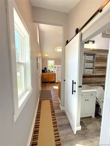 a view of a hallway with workspace and wooden floor