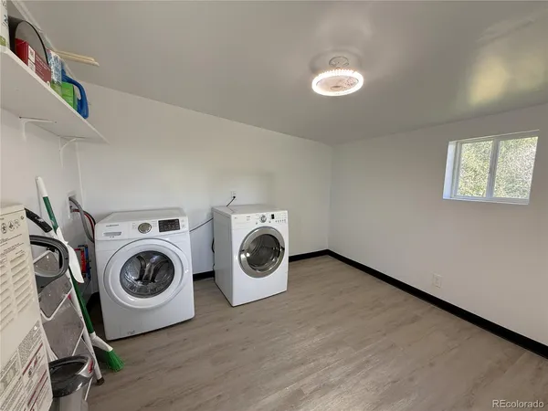 a view of a hallway with wooden floor and a washer dryer