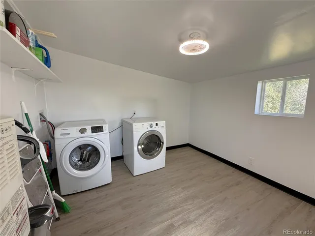 a view of a hallway with wooden floor and a washer dryer
