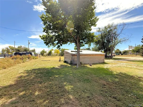 a view of a house with backyard and wooden fence