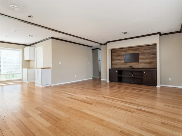 a view of empty room with wooden floor and window