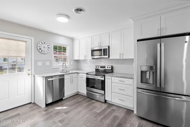 a kitchen with white cabinets and stainless steel appliances