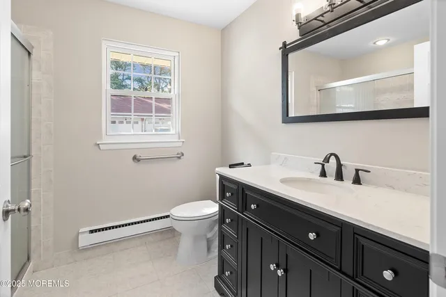 a view of a white house with a big yard plants and large tree