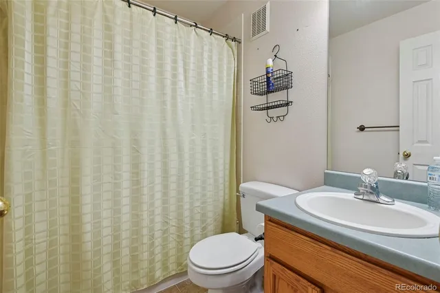a bathroom with a sink a toilet and shower curtain