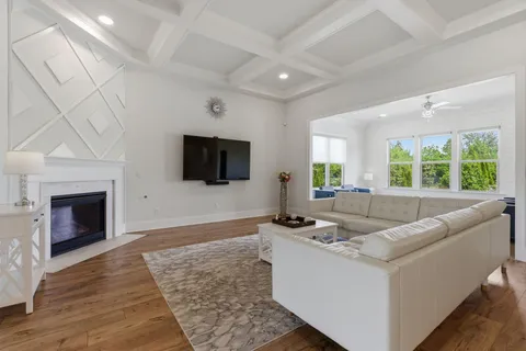 a kitchen with stainless steel appliances kitchen island granite countertop a stove a refrigerator a sink a dining table and chairs with wooden floor