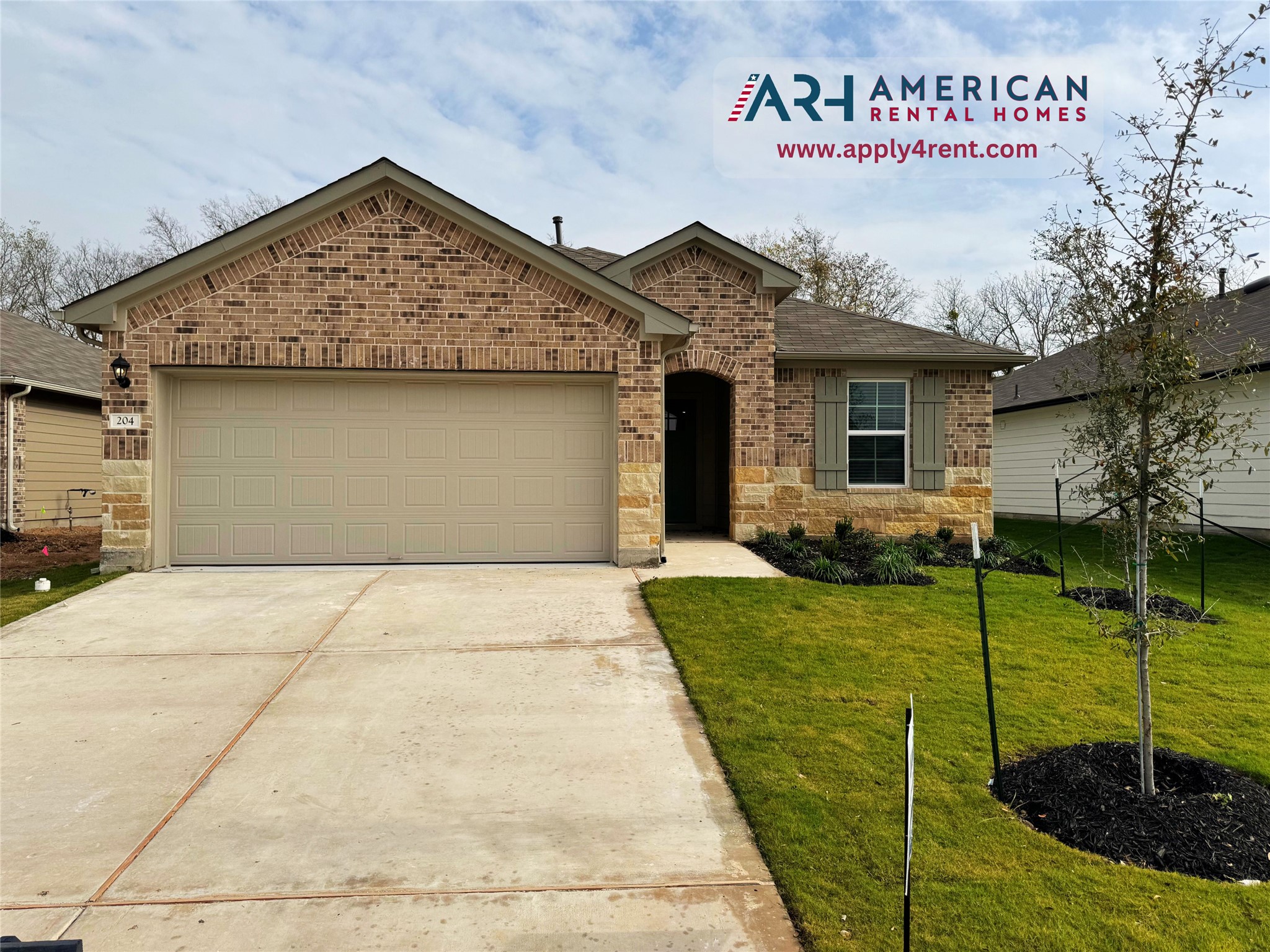 View of front of property with brick siding, an attached garage, concrete driveway, and a front lawn