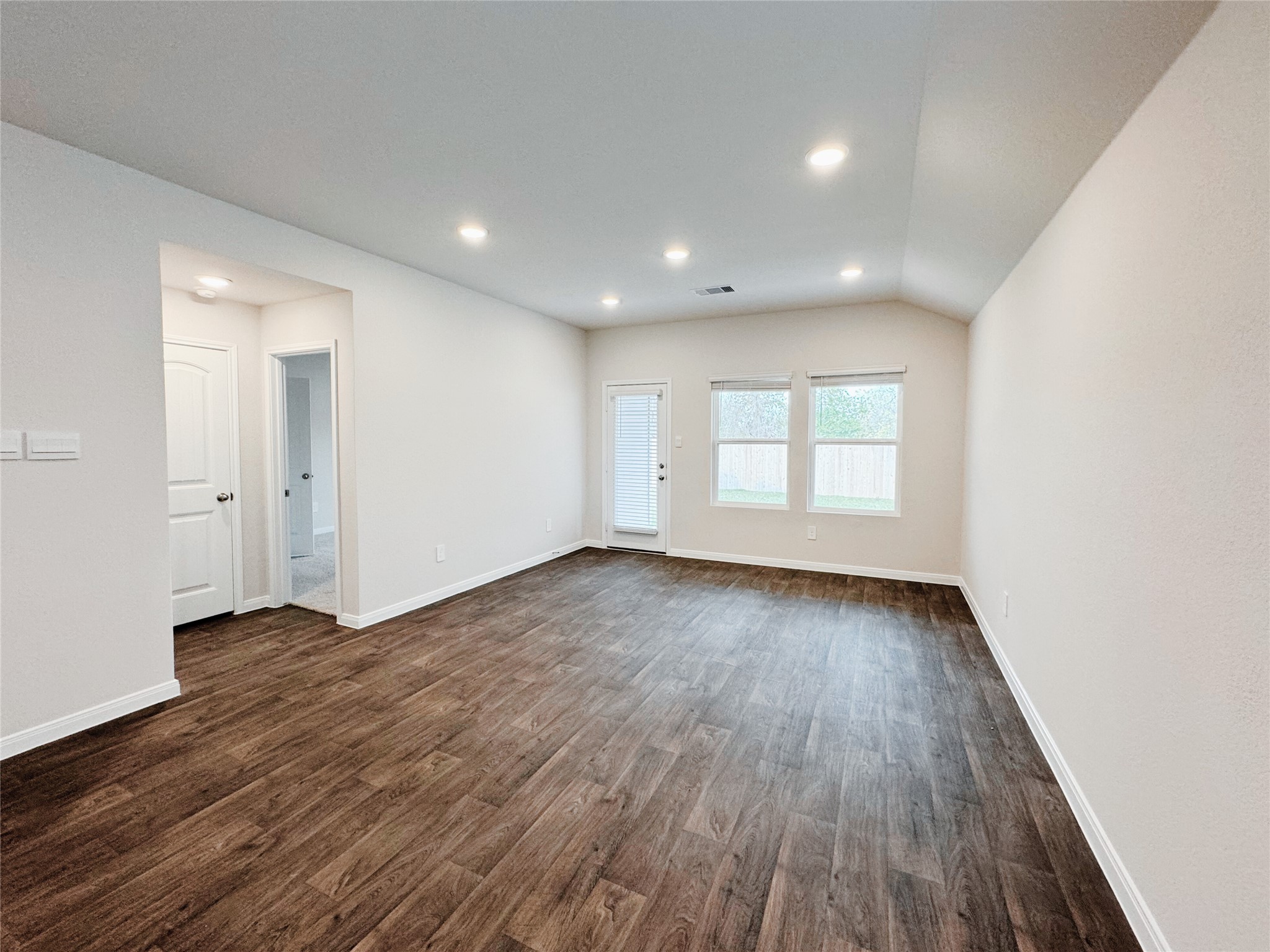 204 Addison Place Lockhart, TX 78644 - Photo 11 of 39 Unfurnished room with dark wood-style floors, recessed lighting, and lofted ceiling