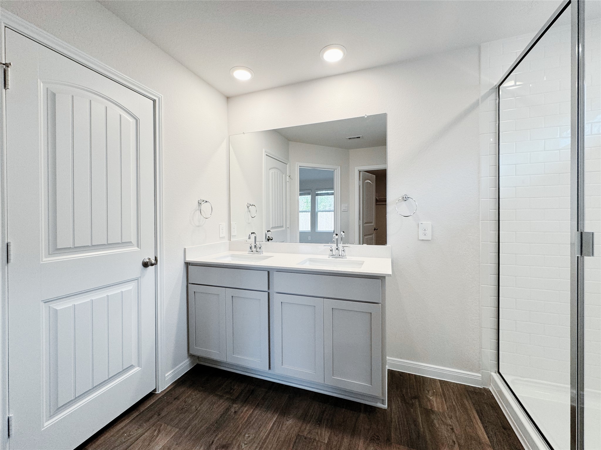 204 Addison Place Lockhart, TX 78644 - Photo 14 of 39 Full bathroom featuring a shower stall, double vanity, and dark wood finished floors