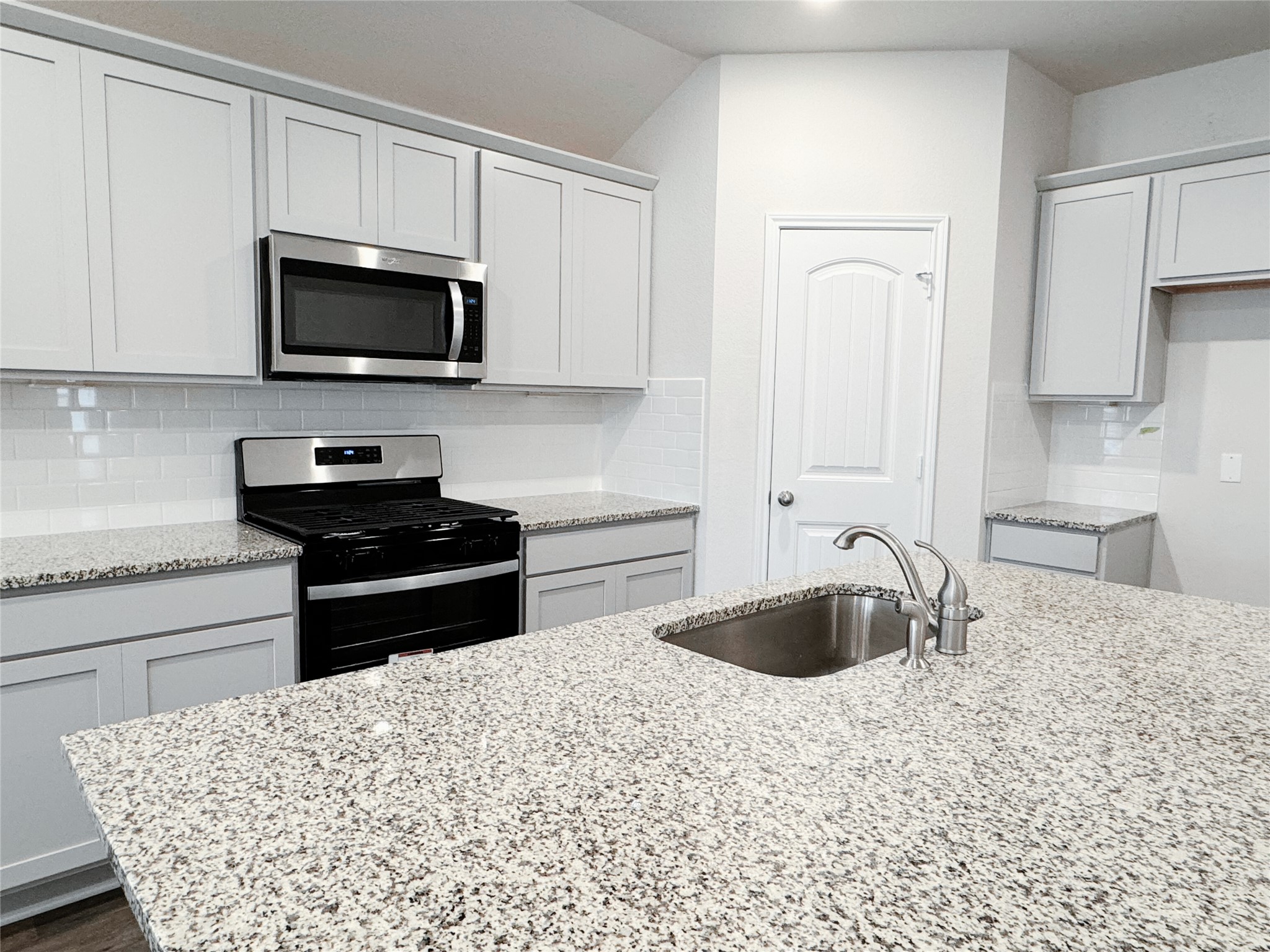 204 Addison Place Lockhart, TX 78644 - Photo 8 of 39 Kitchen with stainless steel appliances, decorative backsplash, and light stone countertops