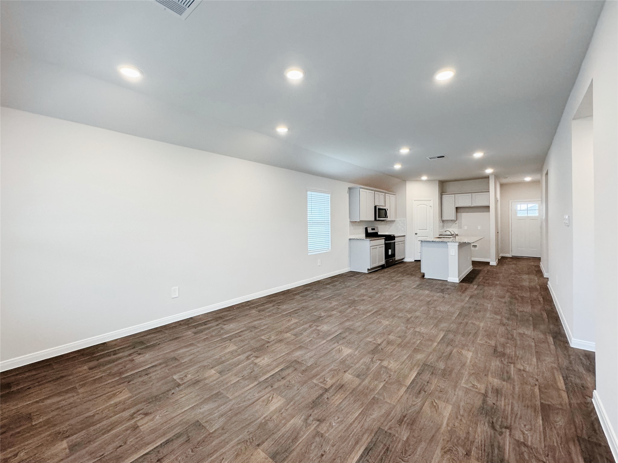 204 Addison Place Lockhart, TX 78644 - Photo 9 of 39 Unfurnished living room with dark wood-type flooring and recessed lighting