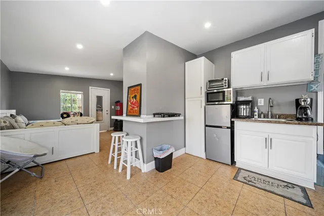a kitchen with a refrigerator and white cabinets
