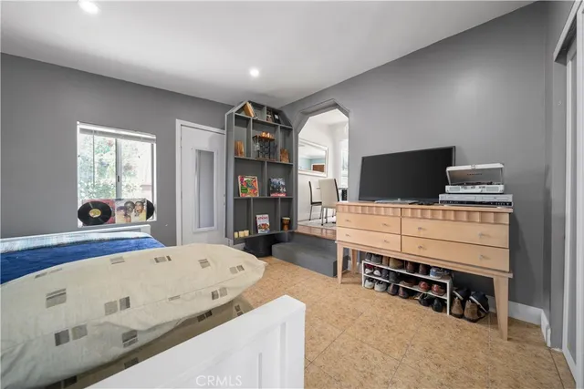 a living room with a baby crib furniture and a flat screen tv