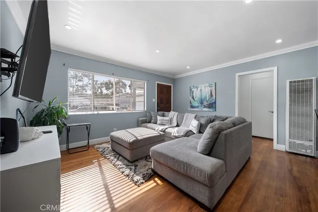 a living room with furniture a large window and a flat screen tv