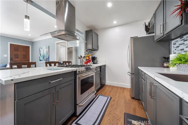 a kitchen with stainless steel appliances granite countertop a sink a stove and a refrigerator