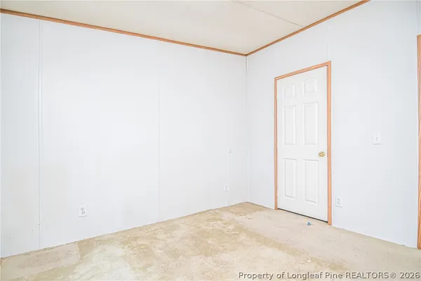 an empty room with windows and refrigerator