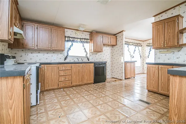 a view of an empty room with a ceiling fan and a fireplace