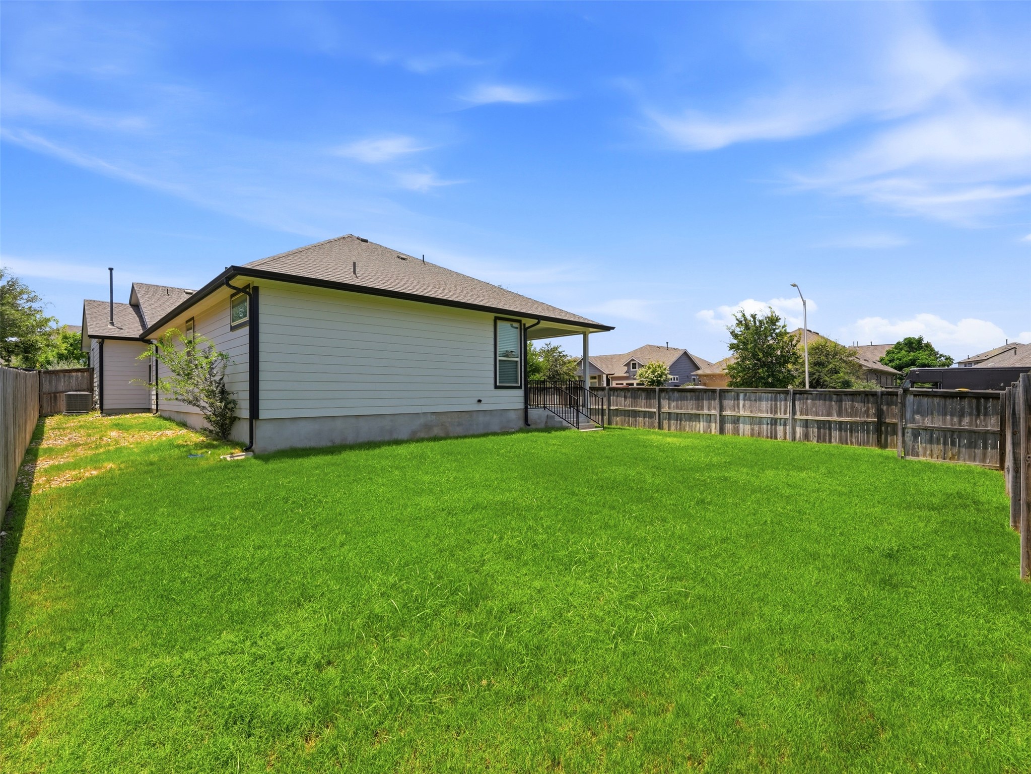 2132 Ringstaff Road Leander, TX 78641 - Photo 34 of 39 A spacious, verdant yard provides ample outdoor living potential, framed by a sturdy wooden fence.
