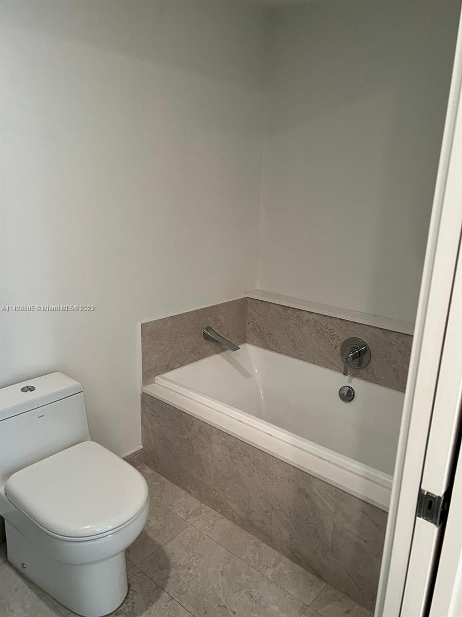 488 Northeast 18th Street, Unit 505 Miami, FL 33132 - Photo 11 of 35 a bath tub sitting next to a white toilet