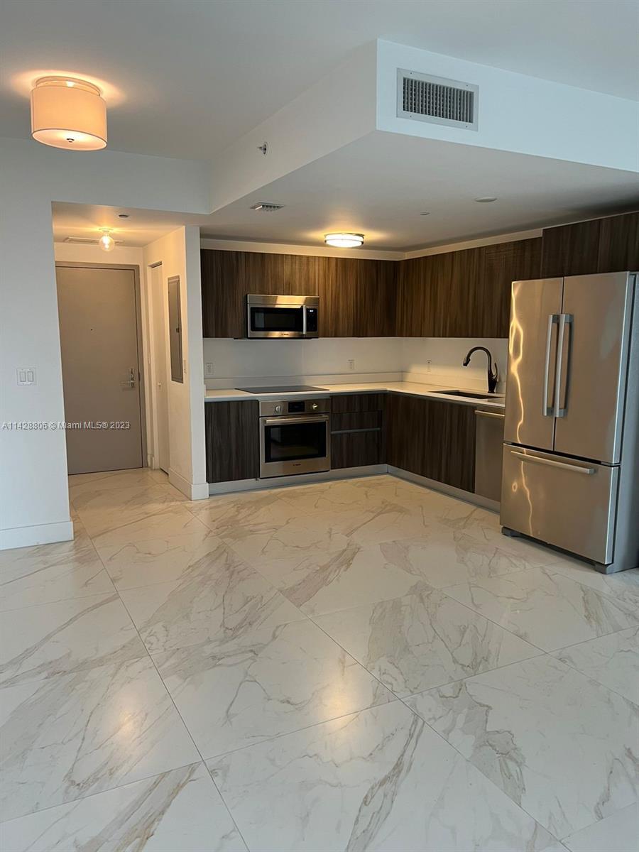 488 Northeast 18th Street, Unit 505 Miami, FL 33132 - Photo 3 of 35 a kitchen with stainless steel appliances a refrigerator and a sink