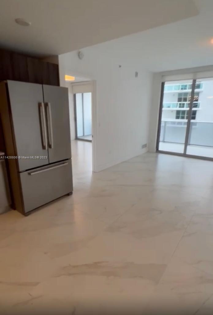 488 Northeast 18th Street, Unit 505 Miami, FL 33132 - Photo 5 of 35 a view of a livingroom with wooden floor and kitchen