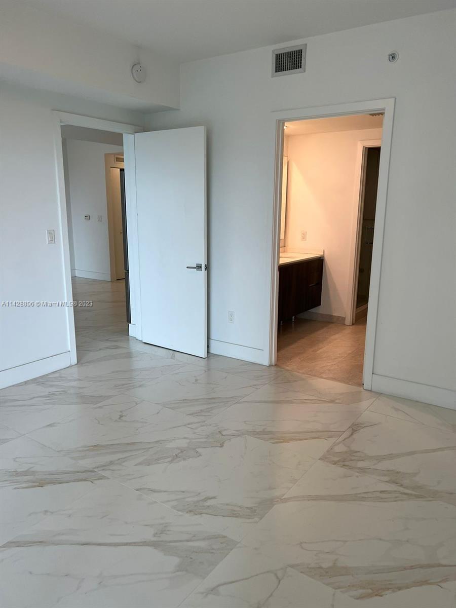 488 Northeast 18th Street, Unit 505 Miami, FL 33132 - Photo 6 of 35 an empty room with wooden floor and cabinet