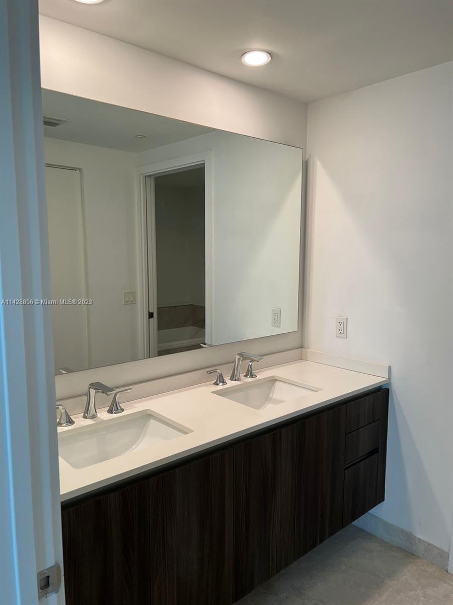 488 Northeast 18th Street, Unit 505 Miami, FL 33132 - Photo 9 of 35 a bathroom with a double vanity sink and a mirror