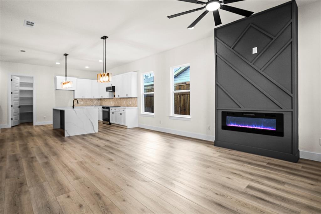 a view of empty room with wooden floor and fireplace