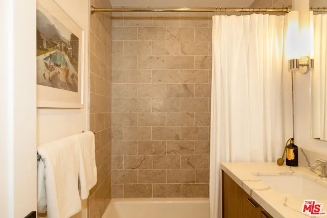a bathroom with a granite countertop sink and a shower