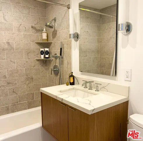 a bathroom with a sink mirror and shower