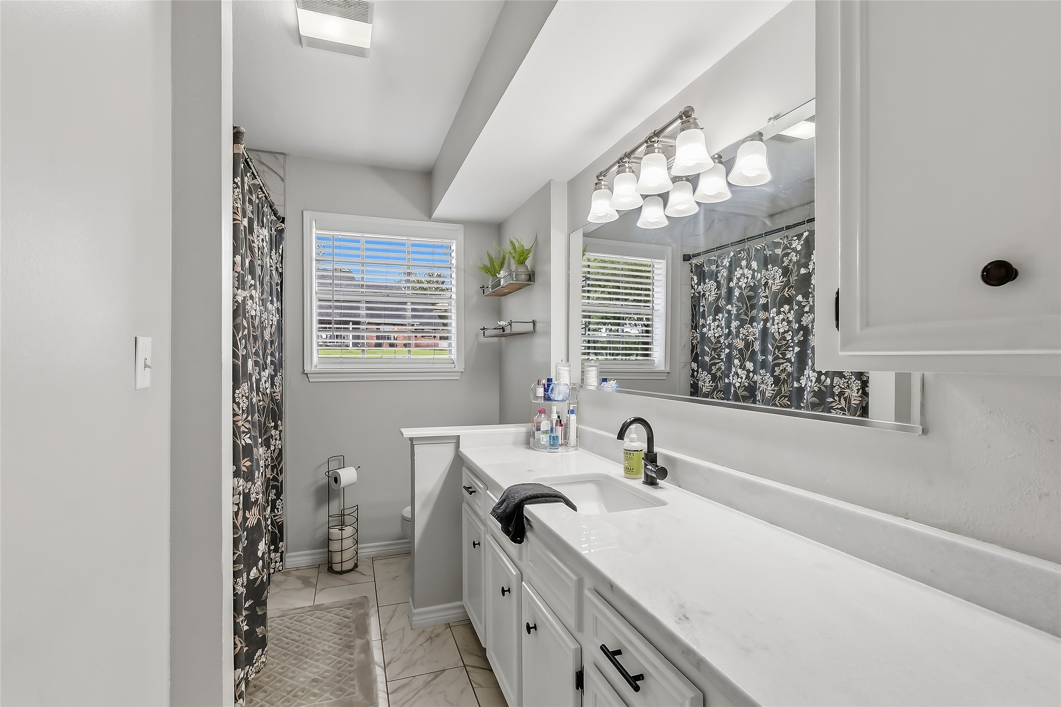 906 Standley Road Madisonville, TX 77864 - Photo 22 of 40 a bathroom with a double vanity sink mirror and shower
