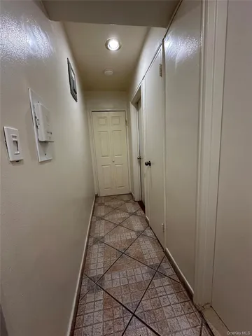 a view of a big room with windows and chandelier fan