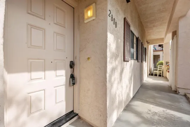 a view of a hallway with wooden floor and furniture