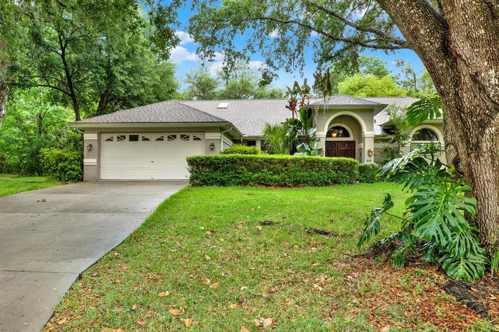 642 Erin Way Brooksville, FL 34601 - Photo 2 of 45 a front view of a house with garden