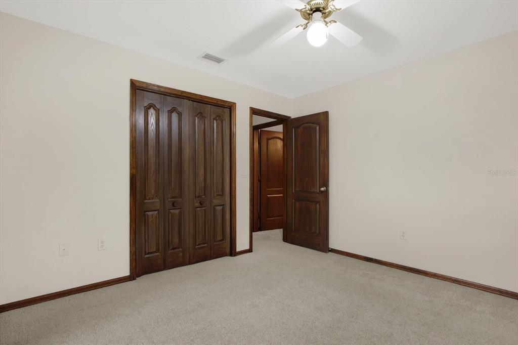 642 Erin Way Brooksville, FL 34601 - Photo 35 of 45 an empty room with a ceiling fan and a window
