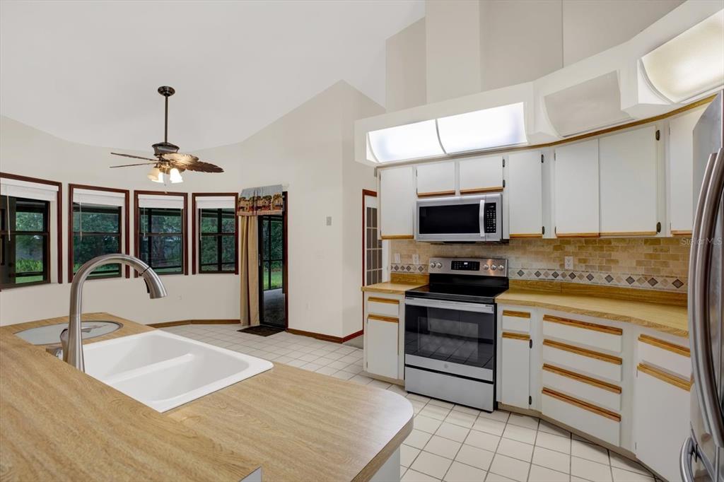 642 Erin Way Brooksville, FL 34601 - Photo 4 of 45 a kitchen with stainless steel appliances granite countertop a stove and a sink with granite countertops