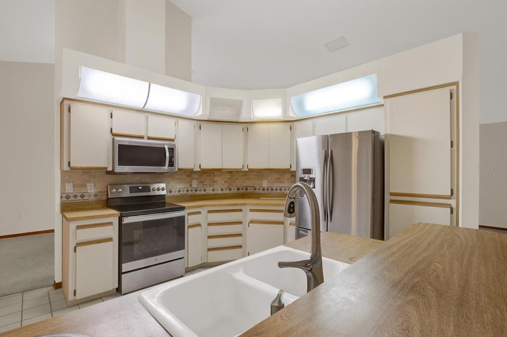 642 Erin Way Brooksville, FL 34601 - Photo 5 of 45 a kitchen with stainless steel appliances a refrigerator stove and microwave