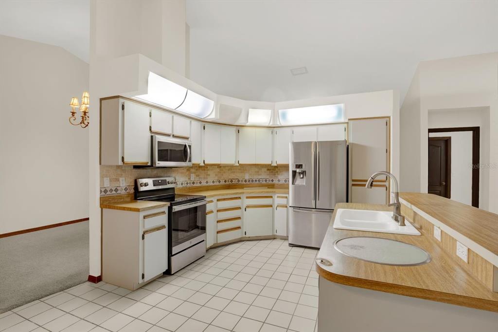 642 Erin Way Brooksville, FL 34601 - Photo 7 of 45 a kitchen with stainless steel appliances a refrigerator stove microwave and sink